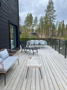 a wooden deck with a table and chairs on it at Villa Valkeinen in Yli-Lesti