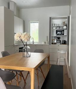 a kitchen with a wooden table with a vase of flowers at Villa Valkeinen in Yli-Lesti