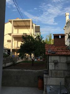 ein Gebäude mit einem Baum vor einem Haus in der Unterkunft Apartment Velada in Hvar