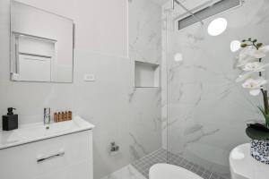 a bathroom with a shower with a toilet and a sink at Modern 3 Bedroom Apartment Full Kitchen Ac in Manati +28 photos