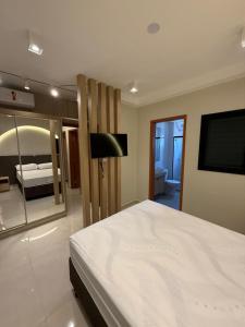 a bedroom with a large bed and a television at High standard apartment, well located in Anápolis +21 photos
