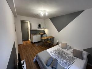a small bedroom with a bed and a kitchen at Studio 29 in Troyes
