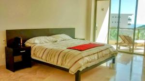 ein Schlafzimmer mit einem Bett und einem Stuhl und einem Fenster in der Unterkunft Luxury 2 bedroom condo by the beach in Tangolunda + 14 Fotos