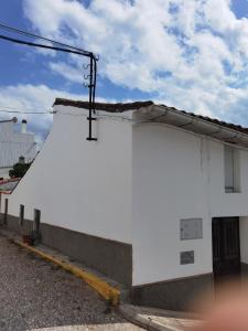 a white building with a pole on the side of it at Casa Rural Galaroza La Bella in Galaroza