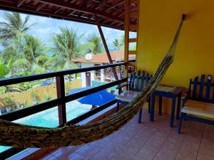 a hammock in a room with a view of the pool at Pousada Praia do Amor Pipa in Pipa