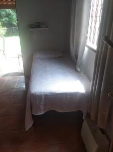 un piccolo letto in una stanza con una finestra di Aconchego II a Foz do Iguaçu