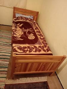 a wooden bed in a corner of a room at Școala Zamolxiană in Predeal