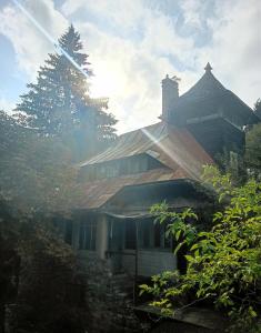 a house with a gambrel roof on top of it at Școala Zamolxiană in Predeal