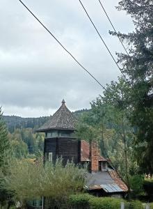 an old building with a tower on a hill at Școala Zamolxiană in Predeal