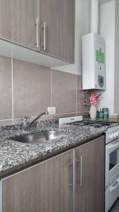 a kitchen with a sink and a stove at Garage y Gimnasio Depto Ideal Villa Dolores in Villa Dolores +24 photos