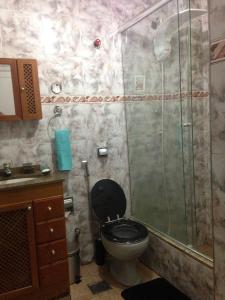 a bathroom with a toilet and a glass shower at Méier House in Rio de Janeiro