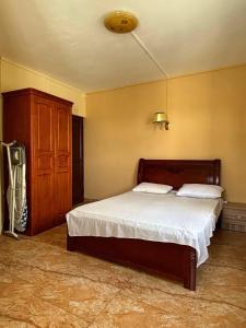 a bedroom with a bed and a wooden cabinet at Bonzour Tropical Apartments l 2 Bedrooms l Pool l Equipped kitchen l Cosy l Trou aux Biches l Mauritius in Trou aux Biches