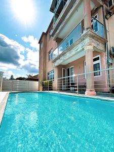a swimming pool in front of a house at Bonzour Tropical Apartments l 2 Bedrooms l Pool l Equipped kitchen l Cosy l Trou aux Biches l Mauritius in Trou aux Biches