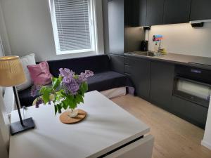 a living room with a couch and a table with flowers on it at Apartment in Sollentuna Centrum 1205 in Sollentuna