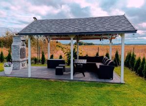 a pavilion with a table and chairs in a field at Podamirowo Domki Nad Jeziorem in Podamirowo