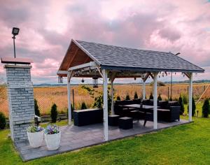 a pavilion with couches and tables in a field at Podamirowo Domki Nad Jeziorem in Podamirowo