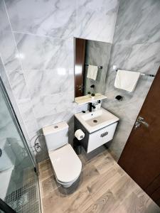 a bathroom with a toilet and a sink at Centre-ville - bien équipé - Neuf - WiFi - Calme in Kenitra +14 photos