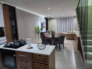 a kitchen and living room with a stove and a table at Home Sweet Luxe Stays in Lobamba