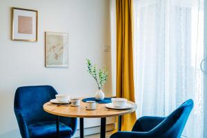 un tavolo con due sedie blu e un vaso sopra di Studio Vintage by Gestion ELITE a Mont-Tremblant Altre 14 foto