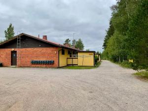 ein rotes Backsteingebäude mit einer gelben Garage in der Unterkunft Studio Sulkava - Cozy studio with sauna and yard in Sulkava