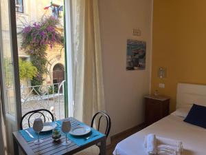 a room with a bed and a table and a window at Il portale in Tropea