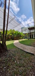 a walkway in front of a building with trees at Ecopousada Miriti in Belém