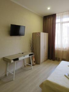 a room with a desk and a television on the wall at Just comfort in Odesa