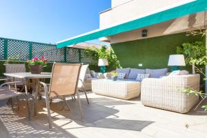 a patio with chairs and a table and a couch at AMAZING ROOFTOP, 70 M TERRACE,Pool,BEACH,PARKING in Málaga