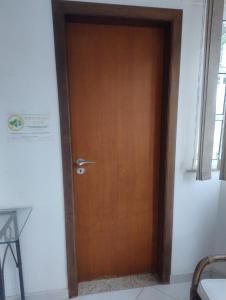 Una puerta de madera en una habitación con ventana en Pousada Tia Cida, en Guarujá