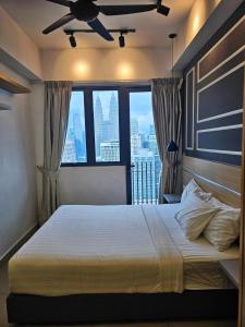 a bedroom with a bed with a ceiling fan at The Infinitum Eternity Luxe By Crystal KLCC in Kuala Lumpur