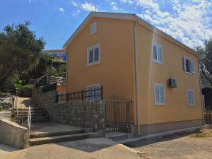 a small yellow house with stairs and a fence at Žanjice Luxury Suite in Lustica