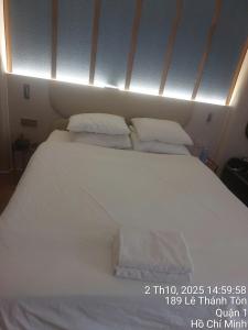 a large bed with white sheets and pillows at Sulina Hlels 4 in Ho Chi Minh City
