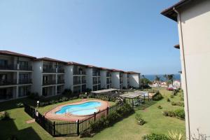 an apartment complex with a swimming pool in a yard at Topanga Beach Apartment in Margate