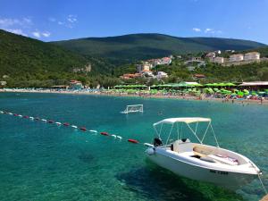 a boat in the water next to a beach at Žanjice Luxury Suite in Luštica