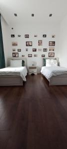 a bedroom with two beds and photographs on the wall at Luxury 4 bedroom villa with hot indoor swimming pool in Cǝnubi