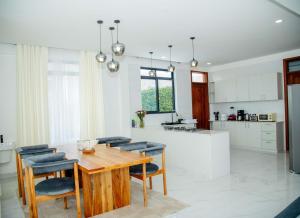 een keuken en eetkamer met een houten tafel en stoelen bij Smile Apartments Arusha in Arusha