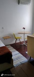 a room with a table and a bed and a table and chairs at Brown Porto Apart in Porto