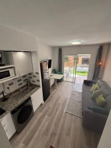 a living room with a couch and a table at Blu Green Oasis 1214 By Lucapropertiesgrancanaria in Maspalomas