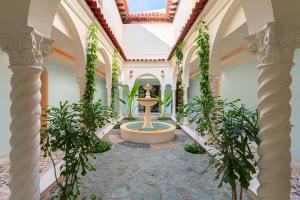 a courtyard with a fountain in the middle of a building at Casa Stella Rooms in Cartagena de Indias