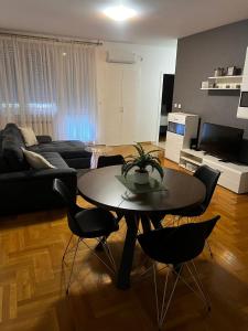 a living room with a table and chairs at New Apartment CRISTAL in the city centre in Novi Sad