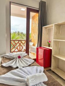 a room with a bed with a view of a balcony at Pousada Villa Pontinha in Icaraí