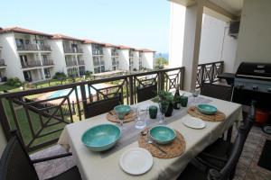 a table with plates and bowls on a balcony at Topanga Beach Apartment in Margate