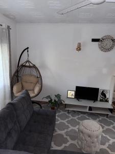 un salon avec un canapé et une télévision dans l'établissement Raine house, à Ukunda
