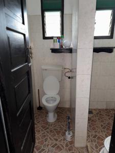 une salle de bain avec toilettes et fenêtre dans l'établissement Raine house, à Ukunda