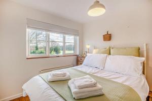 a bedroom with a white bed with towels on it at Bakers Cottage - Sidestrand in Sidestrand