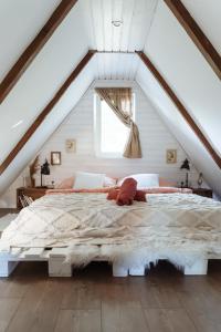 ein Schlafzimmer mit einem großen Bett im Dachgeschoss in der Unterkunft Erdőalján Házikó in Sukoró + 18 Fotos