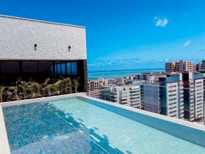 a swimming pool on the roof of a building at Edifício SKY Acomodações in Maceió