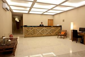 a man standing behind a wooden door in a lobby at Hotel Granja Brasil Resort in Itaipava