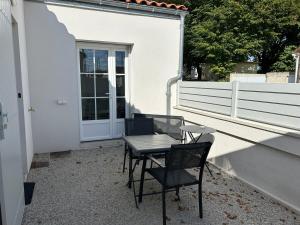 a table and chairs sitting on a patio at Chez Céline et Frédéric T2 45m carré neuf in Rochefort