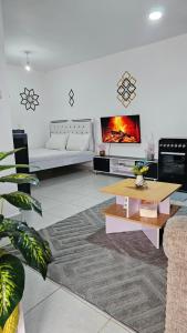 a living room with a table and a tv at Executive Studio in Juja
